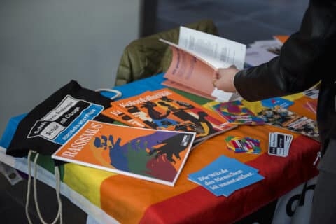 Auf einem Tisch liegen Broschüren und Merch-Artikel des Netzwerks "Schule ohne Rassismus - Schule mit Courage".